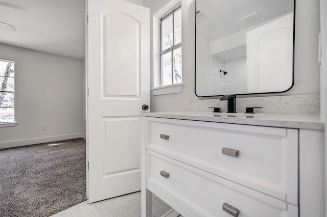 bathroom with baseboards, a wealth of natural light, and vanity