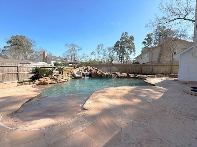 view of pool with a fenced in pool, a water slide, a fenced backyard, and a patio