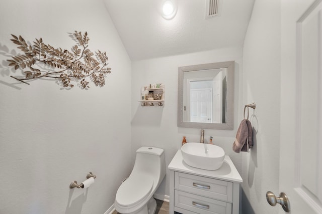 bathroom featuring visible vents, vanity, and toilet