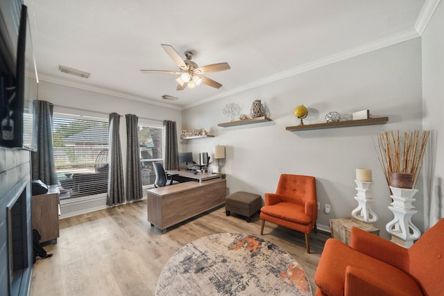 office area with a ceiling fan, baseboards, visible vents, light wood finished floors, and crown molding