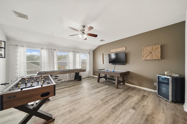 rec room featuring baseboards, visible vents, vaulted ceiling, and light wood finished floors