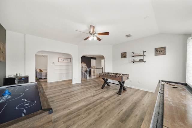 playroom with a ceiling fan, visible vents, arched walkways, and wood finished floors