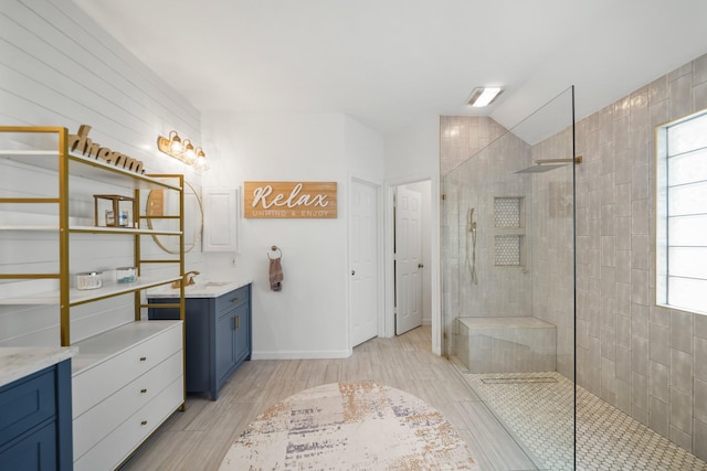 bathroom featuring lofted ceiling, walk in shower, and vanity