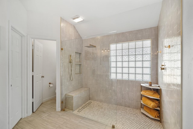 bathroom featuring lofted ceiling and walk in shower