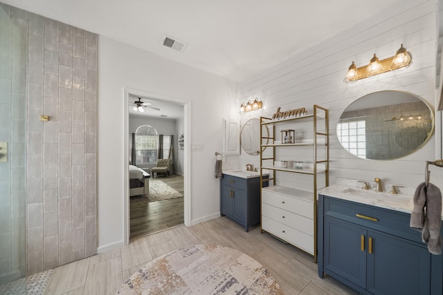 bathroom with visible vents, ensuite bathroom, a sink, wood tiled floor, and two vanities