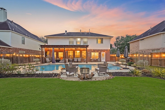 rear view of property with a fenced in pool, a lawn, a patio, a fenced backyard, and an outdoor living space