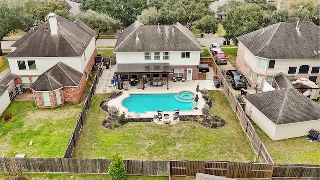 view of swimming pool featuring a fenced backyard, a pool with connected hot tub, a lawn, and a patio