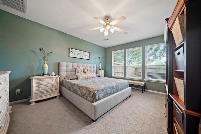 bedroom featuring light colored carpet, visible vents, ceiling fan, and baseboards