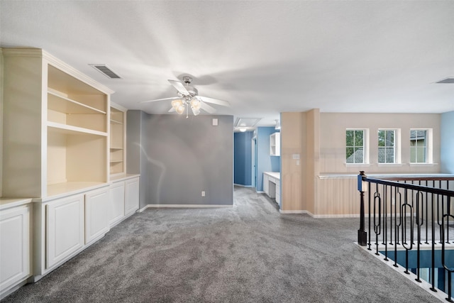 carpeted spare room with visible vents, ceiling fan, and baseboards