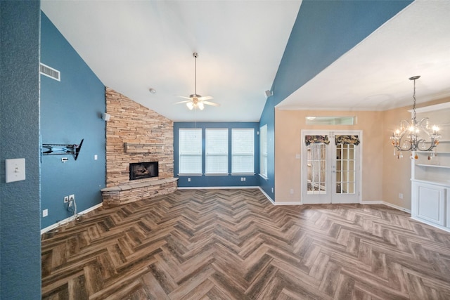 unfurnished living room with ceiling fan with notable chandelier, french doors, a fireplace, and baseboards