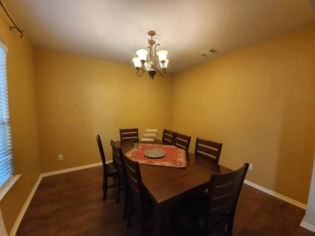 dining area with a notable chandelier, dark wood-style flooring, visible vents, and baseboards