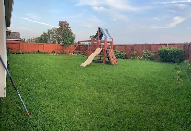 view of jungle gym featuring a fenced backyard and a lawn