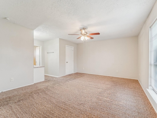 empty room with carpet, ceiling fan, and a textured ceiling