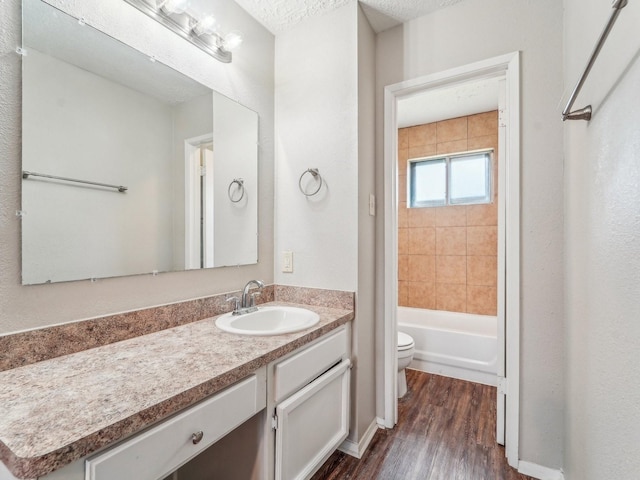 full bathroom featuring toilet, shower / tub combination, wood finished floors, and vanity