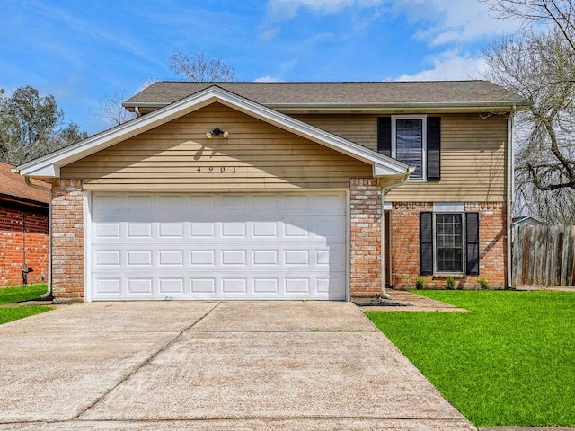 traditional-style house with a garage, concrete driveway, fence, a front lawn, and brick siding