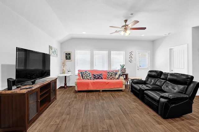 living area with lofted ceiling, ceiling fan, baseboards, and wood finished floors