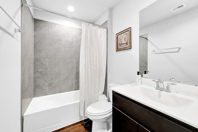 full bathroom with toilet, wood finished floors, vanity, visible vents, and shower / tub combo with curtain