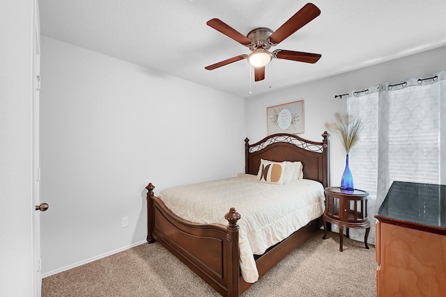 carpeted bedroom with a ceiling fan and baseboards