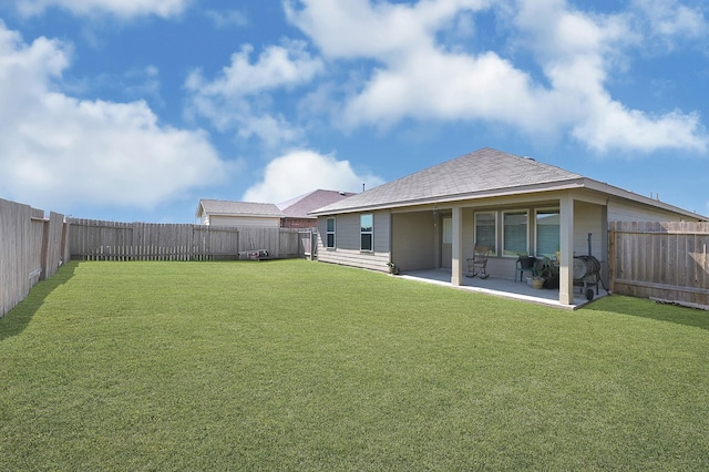 rear view of property with a fenced backyard, a yard, and a patio