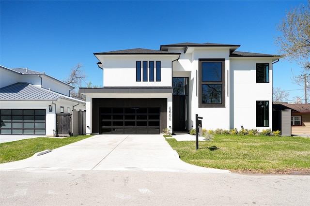 view of front of property with concrete driveway, a front yard, stucco siding, a garage, and a gate