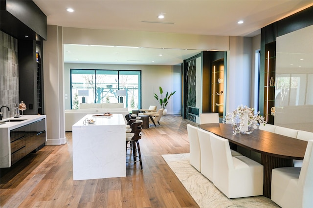 dining room with recessed lighting, light wood-type flooring, and baseboards