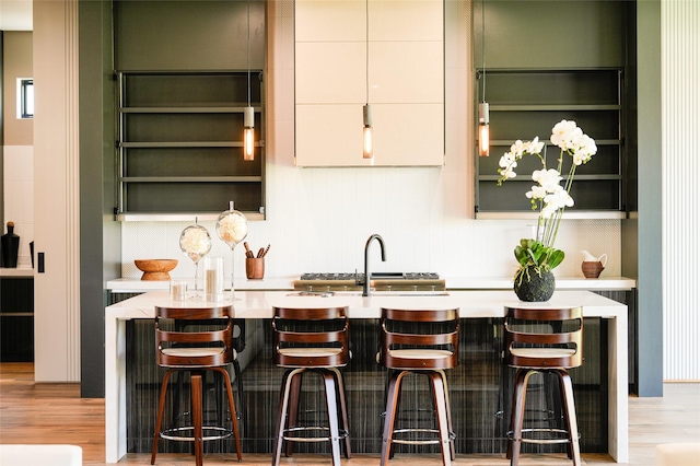 bar featuring light wood-style floors and a sink