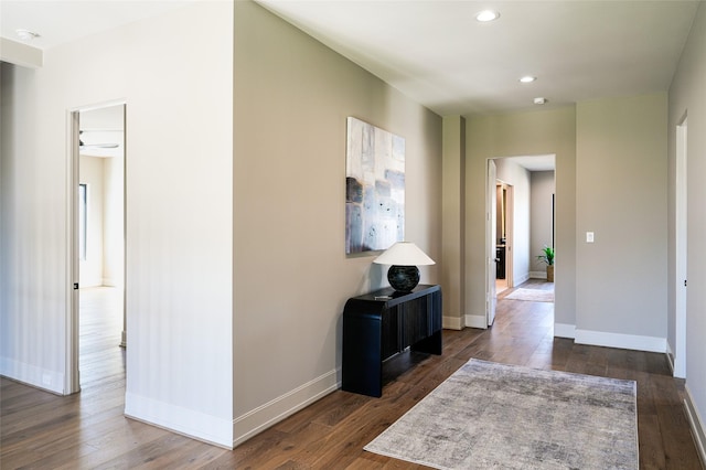 hallway with recessed lighting, dark wood-type flooring, and baseboards