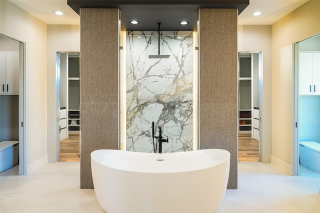 full bathroom featuring recessed lighting, a freestanding tub, a spacious closet, and a walk in shower