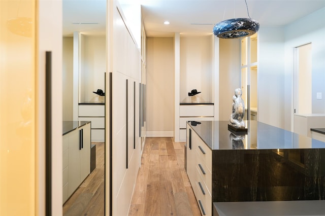 kitchen featuring light wood finished floors, recessed lighting, pendant lighting, white cabinetry, and modern cabinets