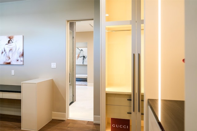 hallway featuring baseboards and wood finished floors