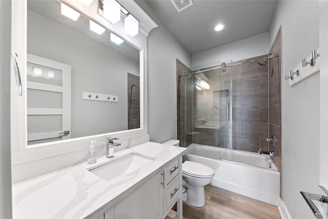 full bath featuring visible vents, toilet, vanity, wood finished floors, and  shower combination