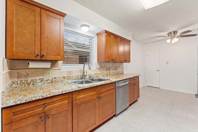 kitchen with stainless steel dishwasher, a sink, light stone countertops, and brown cabinets