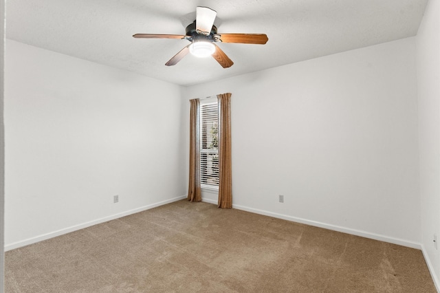 unfurnished room featuring a ceiling fan, light carpet, and baseboards