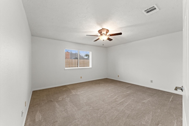 unfurnished room featuring a textured ceiling, ceiling fan, carpet flooring, visible vents, and baseboards