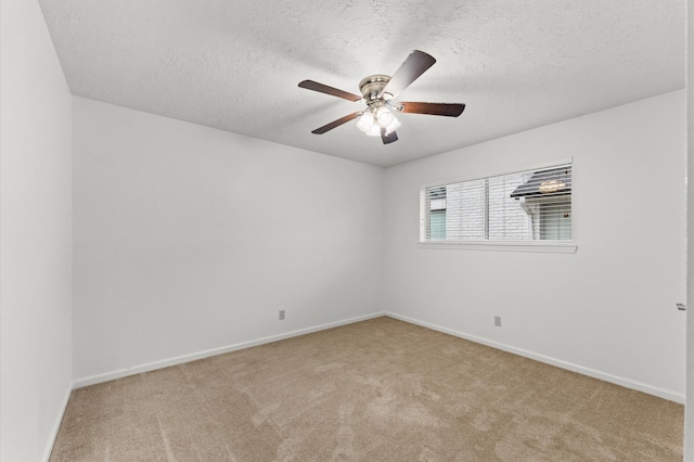 unfurnished room with carpet floors, ceiling fan, a textured ceiling, and baseboards