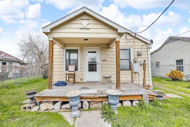 rear view of house featuring fence, a lawn, and a wooden deck