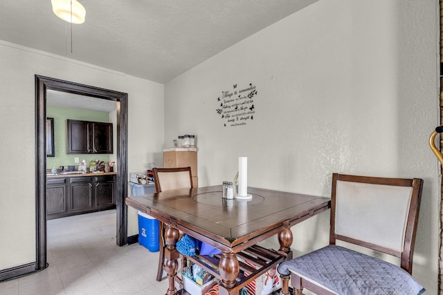 dining area featuring a textured ceiling and baseboards