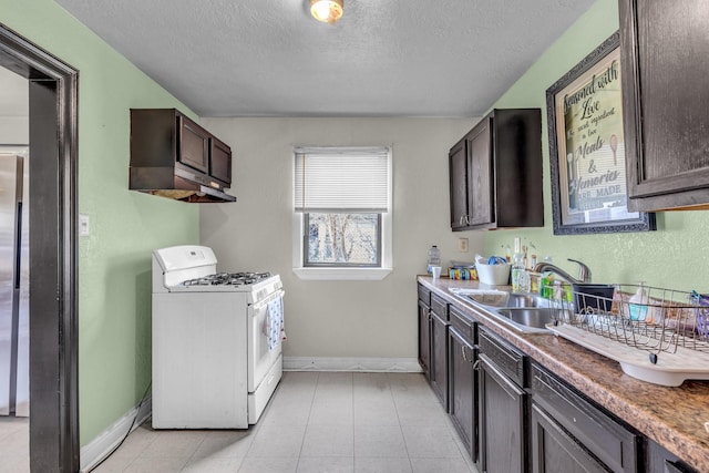 kitchen featuring dark brown cabinetry, white range with gas cooktop, a textured ceiling, and a sink