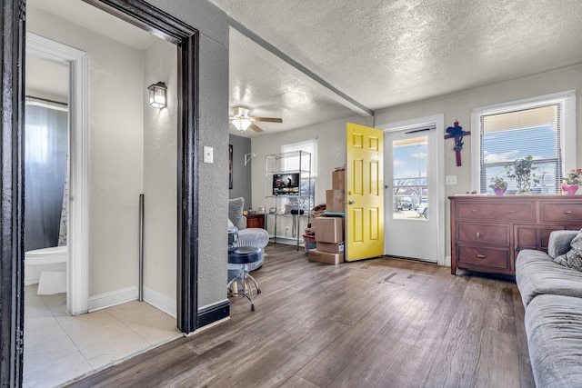 interior space featuring a healthy amount of sunlight, a textured ceiling, wood finished floors, and a textured wall