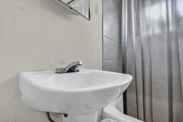 bathroom with a textured wall and a sink