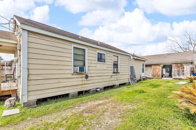 view of property exterior with an outbuilding, a lawn, and cooling unit