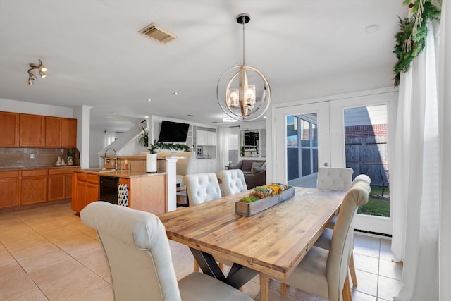 dining area with light tile patterned floors, visible vents, french doors, and an inviting chandelier