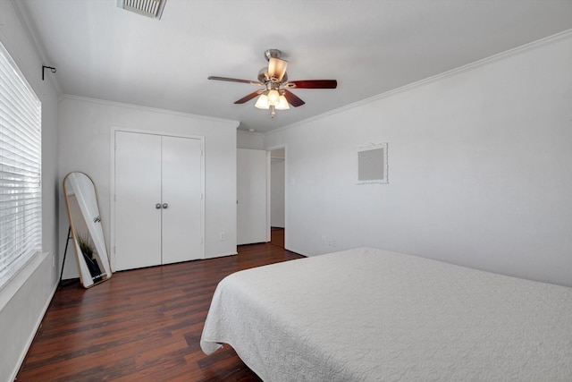 bedroom with a ceiling fan, visible vents, wood finished floors, and ornamental molding