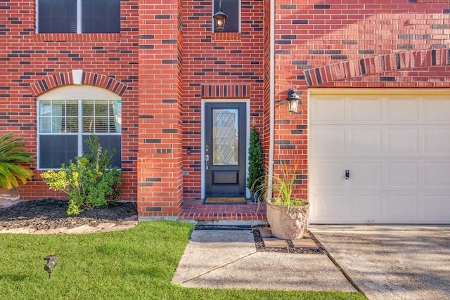 doorway to property with a garage and brick siding