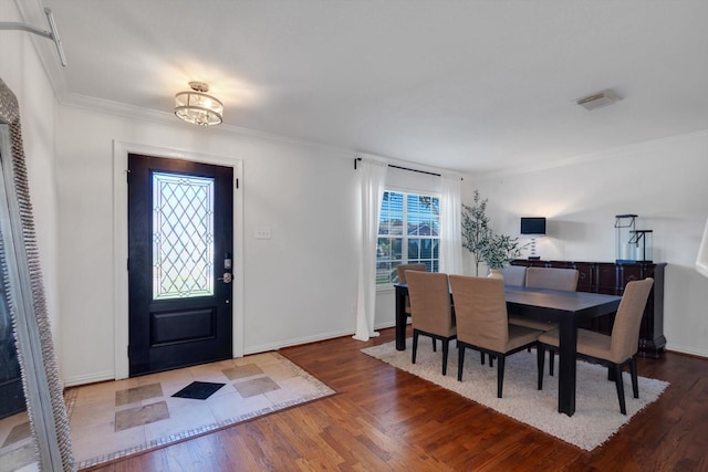 entrance foyer with ornamental molding, baseboards, and wood finished floors