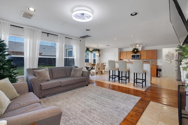 living area with recessed lighting, visible vents, and light wood-style floors