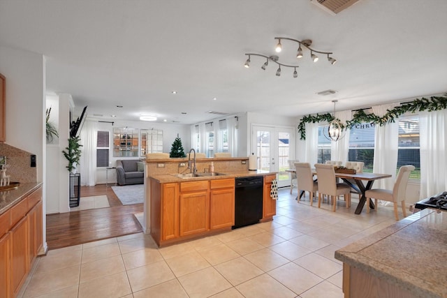 kitchen with light tile patterned floors, visible vents, dishwasher, open floor plan, and a sink