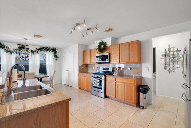 kitchen with decorative backsplash, visible vents, stainless steel appliances, and a sink