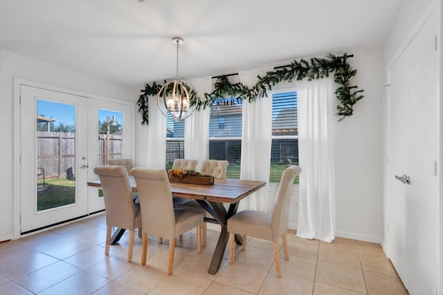 dining space with french doors, a notable chandelier, baseboards, and light tile patterned floors