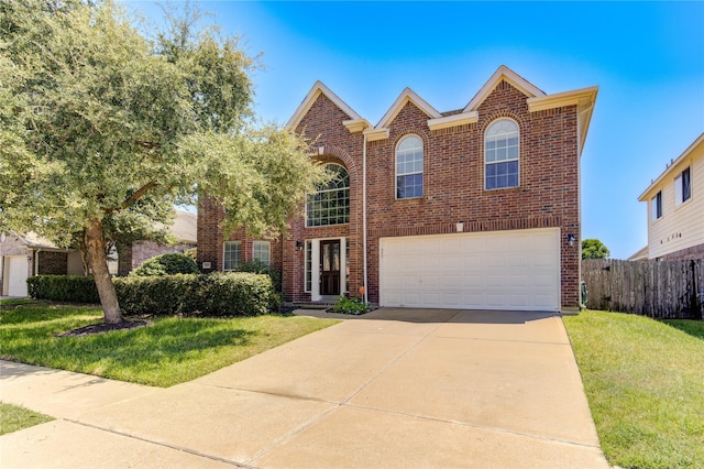 traditional-style house featuring concrete driveway, brick siding, and a front yard